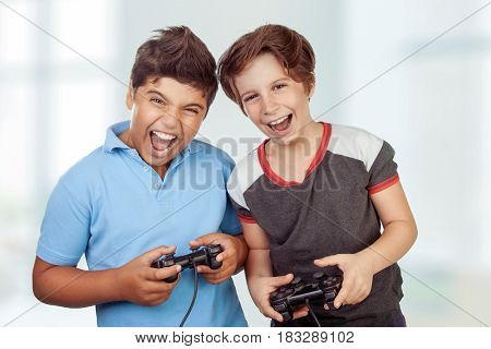 Best friends playing at home, crazy emotion of video games, two excited teen boys enjoying competition, laughing and screaming