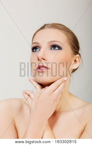 Attractive blonde topless woman with dark eye make up