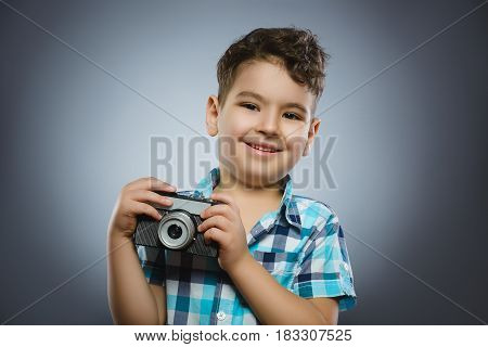 child taking a picture using a retro rangefinder camera isolated grey background.