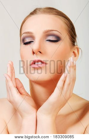 Attractive blonde topless woman with dark eye make up