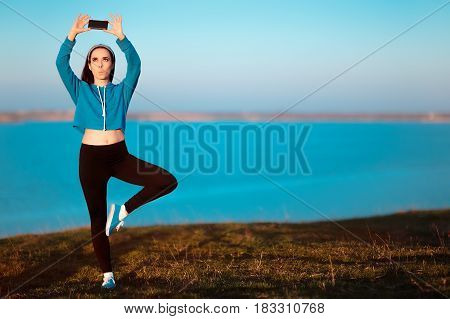 Girl in Yoga Pose Taking a Selfie Outside in Nature
