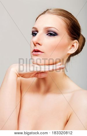 Attractive blonde topless woman with dark eye make up