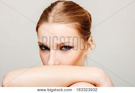 Attractive blonde topless woman with dark eye make up