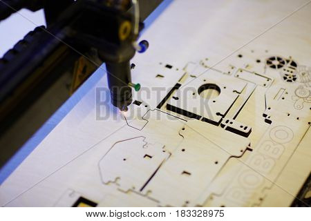 Laser cutter engraving details from veneer wood