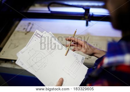 Technical sketches in hand of modern young engineer