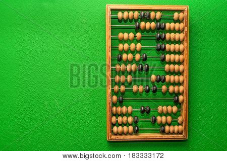 Vintage wooden abacus hangs on green wall