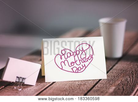 Blank invitation greetings card to replace your design on gray wooden table. Happy mothers day concept