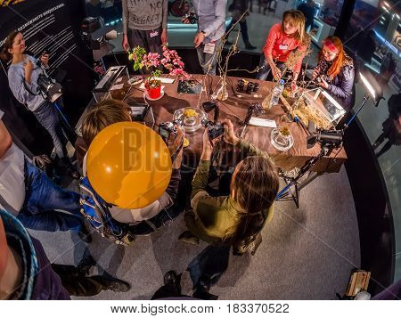 MOSCOW RUSSIA - APRIL 21 2017: Visitors take part in macro photography workshop at booth of Olympus company at PhotoForum 2017 trade show and exhibition in Moscow Russia on April 21 2017.