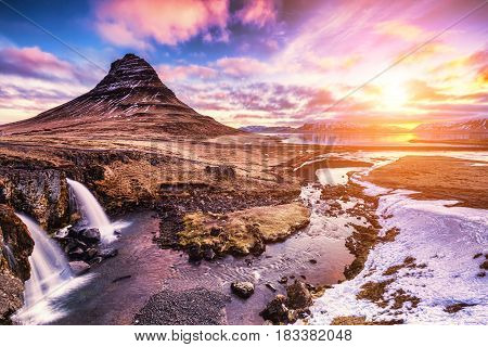 Spring Sunrise Over The Famous Kirkjufellsfoss Waterfall With Kirkjufell Mountain In The Background