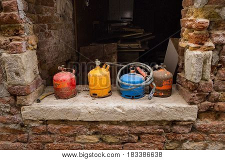 Abandoned old rusty colorful gas cylinders (LPG or Liquefied petroleum gas) with tubes