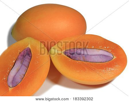 Close-up of Fresh ripe Whole and cut in half with seed Marian Plum fruits Isolated on White Background