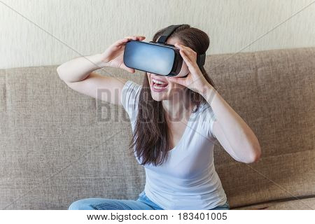 Smile happy woman getting experience using VR-headset glasses of virtual reality at home