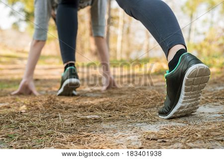 Girl In Sports Pants And Shoes, Stands At The Start Before Running, Leaning Hands, On The Nature.