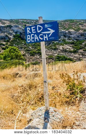 Wood sign showing the direction to a beach on hiking path