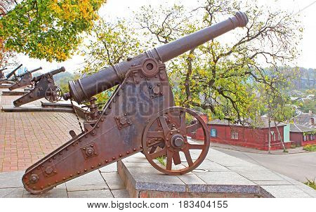 Old cannon in Chernigiv and autumn park as background