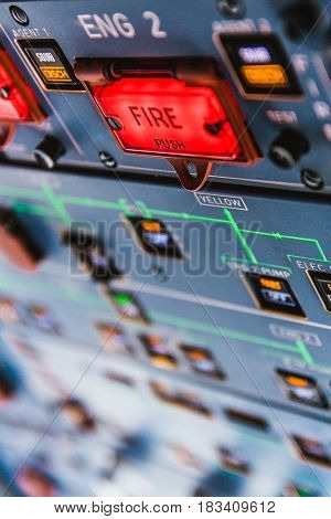 Fire pushbuttons and warning lights on the overhead panel in an airliner cockpit. Bright red warning lights come on when a fire is detected in one of the engines or the APU.