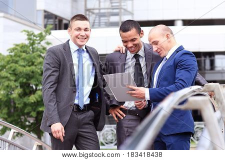 Three Businessmen Discussing Document Outside them Office