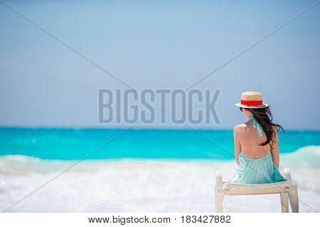Relaxing and enjoying on summer vacation, woman lying in sunbed on beach