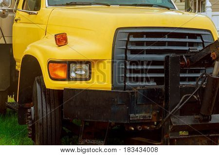 Close up front view of yellow truck vehicle yard yellowpick-uptruck