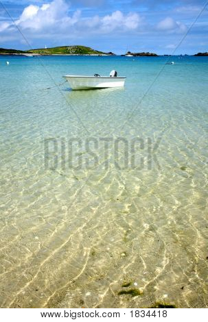Белая лодка, плавающей на ясно море, острова Силли, Корнуолл.