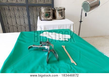 Colposcop spatula and Medical gloves on a clean green blanket (Equipment vaginal speculum) for (Pap smear) gynecology inspect EXAMINATION Cervical cancer