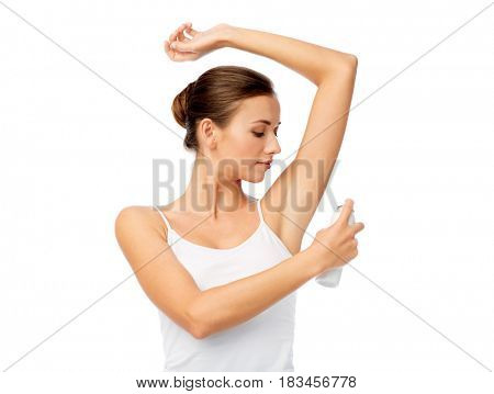 beauty, hygiene, bodycare and people concept - beautiful young woman applying antiperspirant or spray deodorant over white background