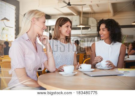 Three Businesswomen Meet In Coffee Shop Shot Through Window