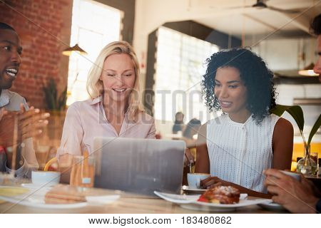 Businesspeople Meeting In Coffee Shop Shot Through Window