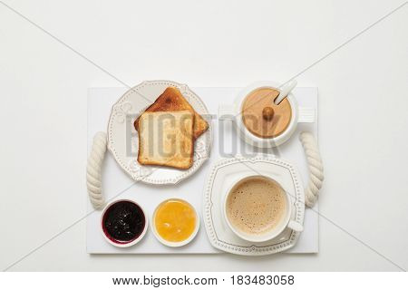 Flay lay of toasts with jams and coffee served on service tray isolated white background 