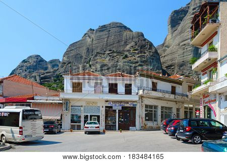 KALAMBAKA GREECE - AUGUST 11 2014: Cars and excursion bus on street of picturesque village of Kalambaka Meteors Greece
