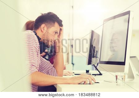 deadline, startup, education, technology and people concept - sad stressed software developer or student with headphones and computer at office