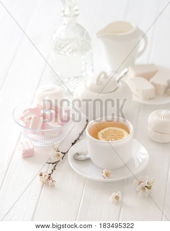 Wonderful and soft tea ceremony set with pink lovely flowers and marshmellow sweets