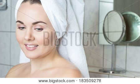 Happy young woman with a white towel on her head. The girl after a shower in a towel.