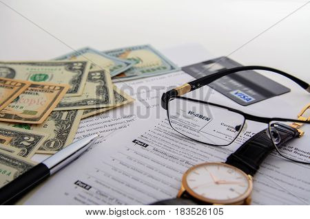 Concept the tax form W-8BEN and over things on the table