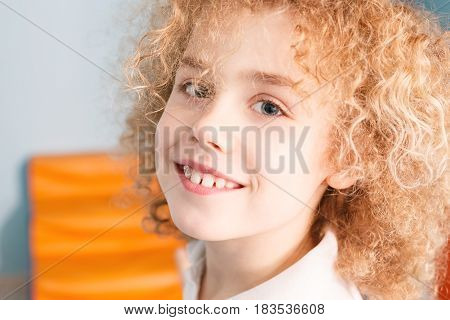 Portrait of happy young boy with blonde curly hair