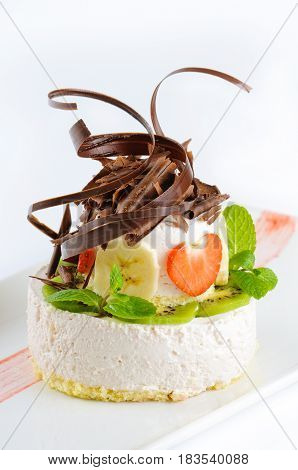 Dessert cheesecake with fruits banana strawberries and chocolate on white