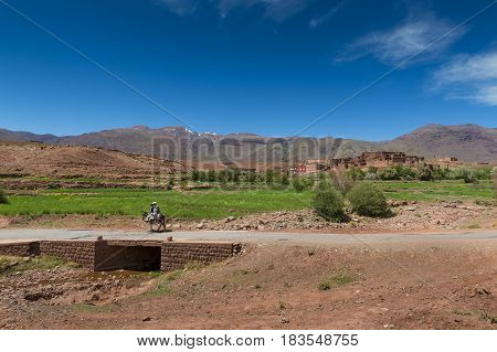 Telouet Morocco - April 14 2016: Father and son riding a donkey in the outskirts of the town of Telouet in the High Atlas region in Morocco.