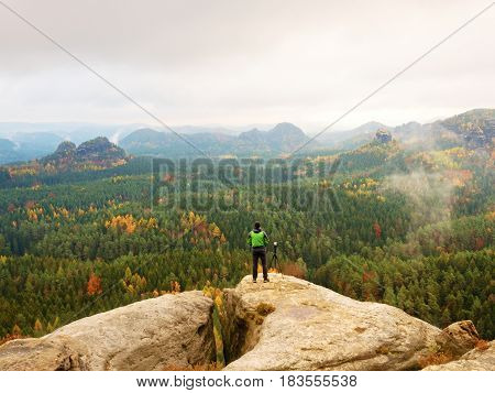 Photographer Working With Mirror Camera And Tripod On Peak Of Rock. Dreamy Fogy Landscape