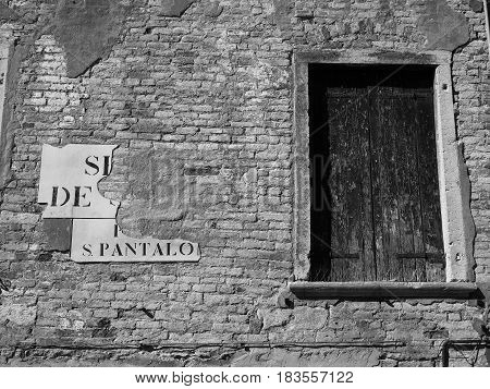 shuttered window on an exterior old brick wall in venice