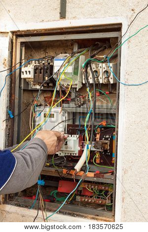 Repair of electricity distribution in an old house. The man repairs the switchboard