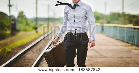 Young businessman in suit with suitcase runs along platform station.