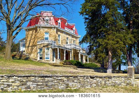 Stone historic mansion built in the 1880s with a large yard taken on the Kansas Plains
