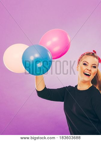 Craziness and lots of fun. Cute crazy joyful girl playing with colored balloons. Blonde playful retro style woman feel craze.