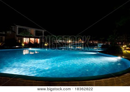 En vacker swimmingpool i natt på en lokal resort
