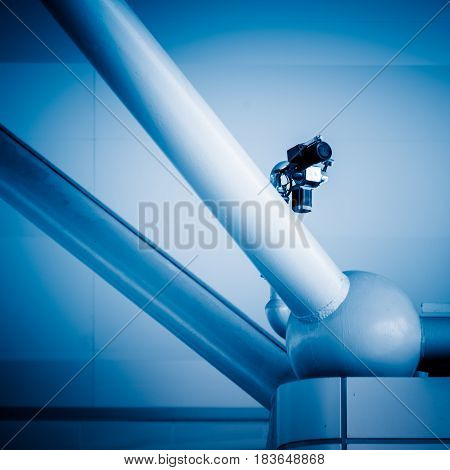 CCTV security camera on building constructure in blue tone.