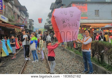 TAIPEI TAIWAN - DECEMBER 5, 2016: Unidentified people fly sky lantern in Shifen town. Shifen is an old railroad town and popular tourist destination.