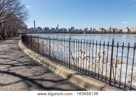 New York City - Panoramic view of modern buildings of Manhattan from Central Park with Jacqueline Kennedy Onassis Reservoir.
