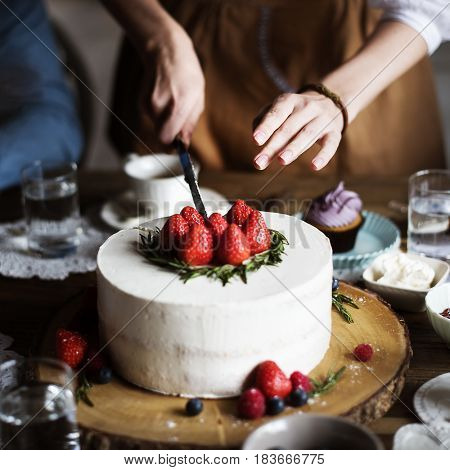 Woman cutting sweet cake to share for the party