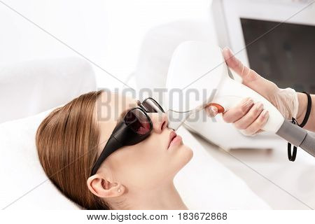Young Woman Receiving Laser Hair Removal Epilation On Face Isolated On White. Laser Skin Care Concep