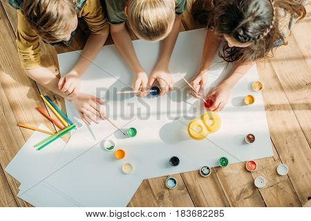 Cute Kids Painting On Paper With While Lying On Floor At Home